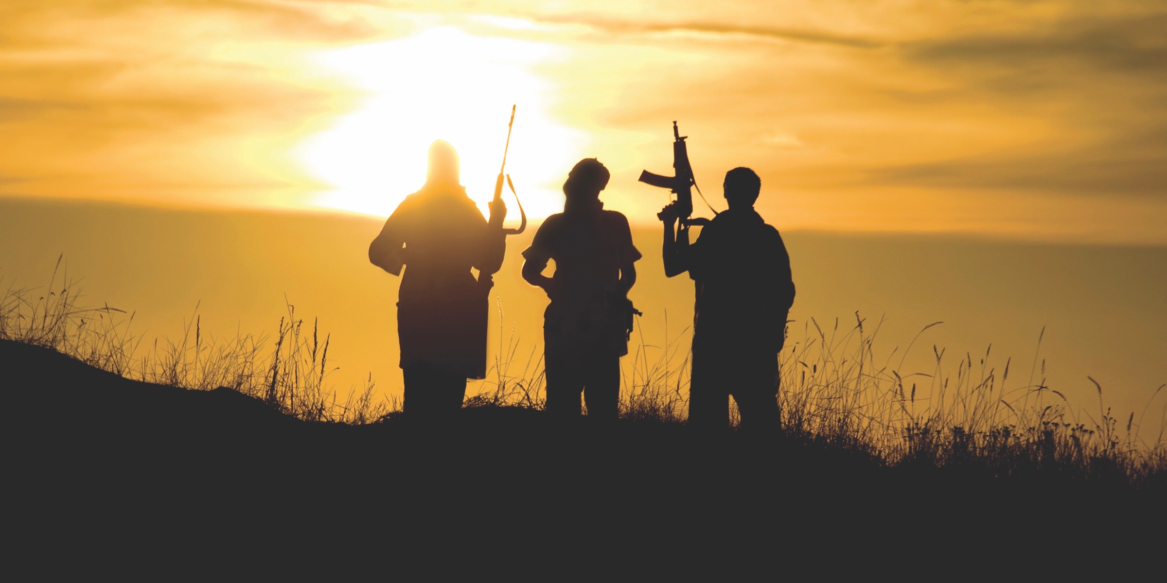 3 men holding rifles overlook the seashore